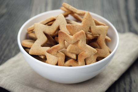 classic star cookies in white bowl, on wood tableの写真素材