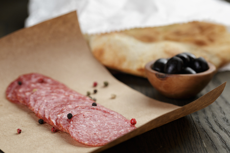 dried salami sausage on paper ready for sandwich, rustic styleの写真素材