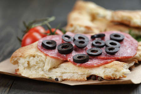 sandwich with pita bread salami and vegetables on wood tableの写真素材