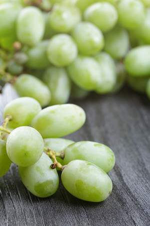 ripe green grapes on black wood tableの写真素材