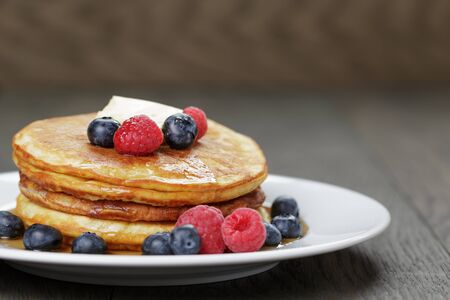 Classic pancakes with butter berrys and maple syrupの写真素材