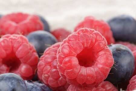 close up photo of ripe  blueberry and raspberryの写真素材