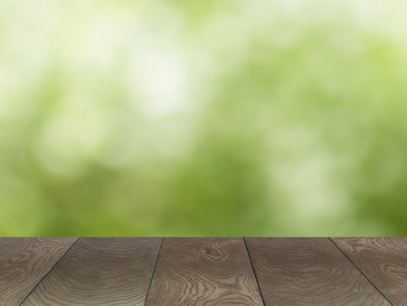 empty wooden table with green summer bokeh backgroundの写真素材