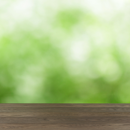 empty wooden table with green summer bokeh backgroundの写真素材