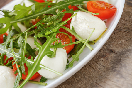 salad with mozzarella cherry tomatoes and arugulaの写真素材