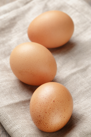whole raw brown eggs closeup on wood table, rustic photoの写真素材