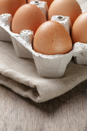 brown raw chicken eggs in container, close up photoの写真素材