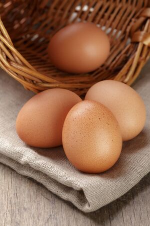 whole raw brown eggs closeup on wood table, rustic photoの写真素材