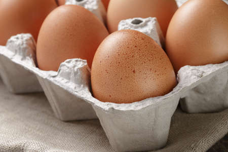 brown raw chicken eggs in container, close up photoの写真素材
