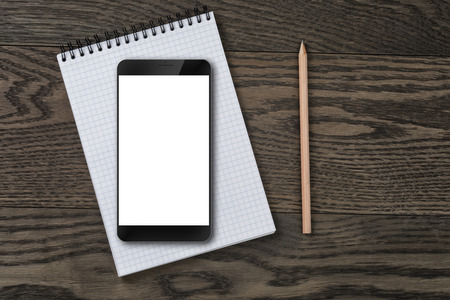 generic modern smartphone on notepad with pencilの写真素材