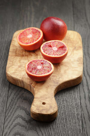 red sicilian oranges sliced on olive boardの写真素材