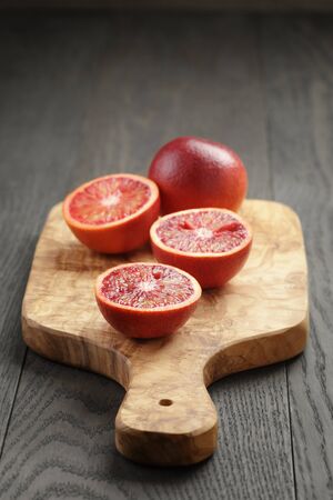 red sicilian oranges sliced on olive boardの写真素材