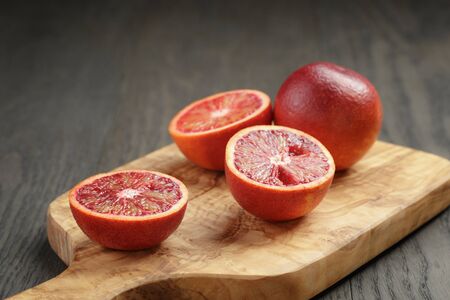 red sicilian oranges sliced on olive boardの写真素材