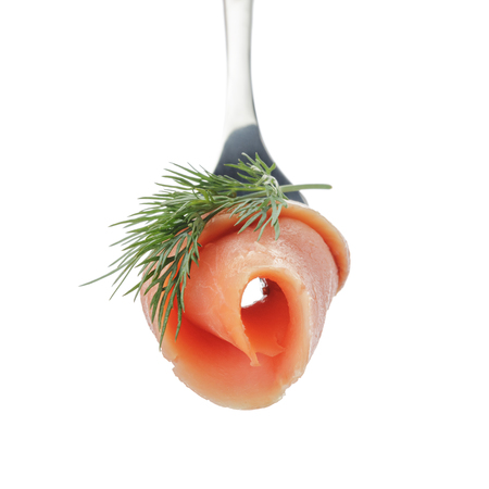 rolled curred salmon on fork with dill isolatedの写真素材
