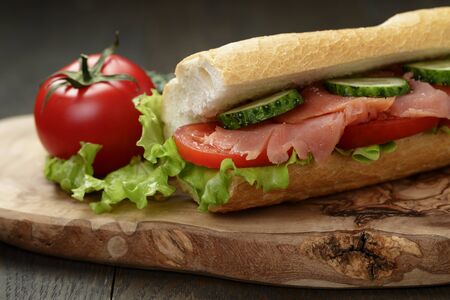 sandwich with salmon and vegetables on wood tableの写真素材