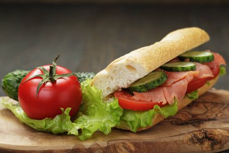sandwich with salmon and vegetables on wood tableの写真素材