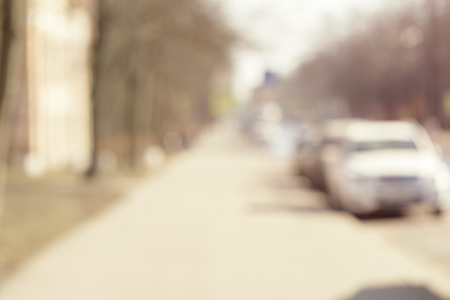 blur background, summer time in town street with parked carsの写真素材