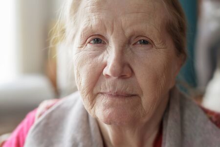portrait of senior woman siting near the windowの写真素材