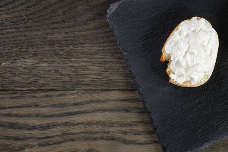 crunchy baguette slices with cream cheese on slate boardの写真素材
