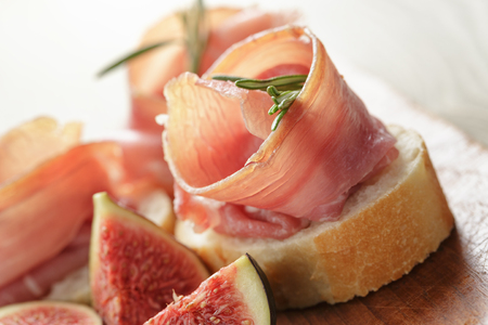 canapes with jamon and figs on wooden boardの写真素材