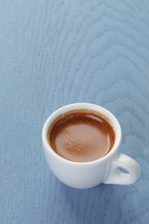 cup of fresh espresso on vintage blue tableの写真素材