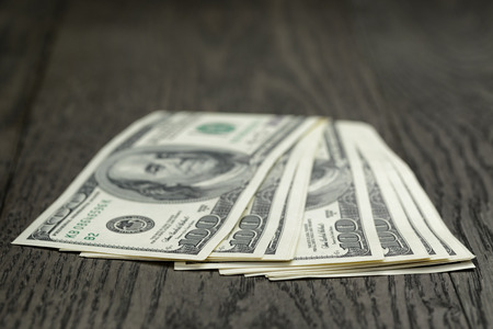 hundred dollar bills on wooden tableの写真素材