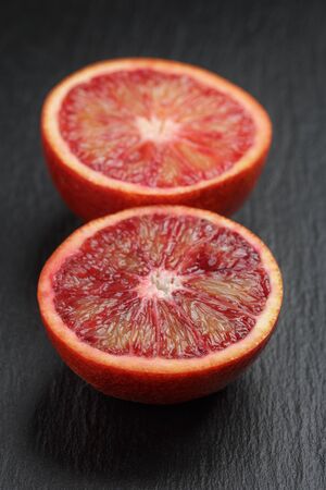 red sicilian oranges sliced on slate boardの写真素材