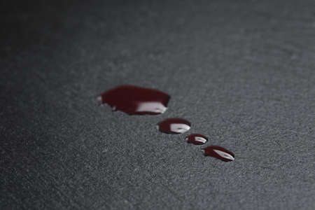 red sicilian juice drops on slate boardの写真素材