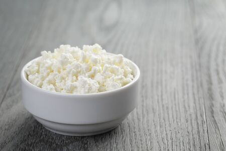 cottage cheese in white bowl on old tableの写真素材