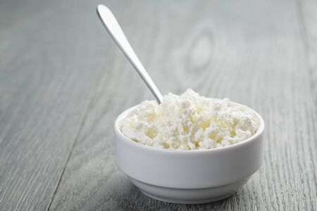 cottage cheese in white bowl on old tableの写真素材