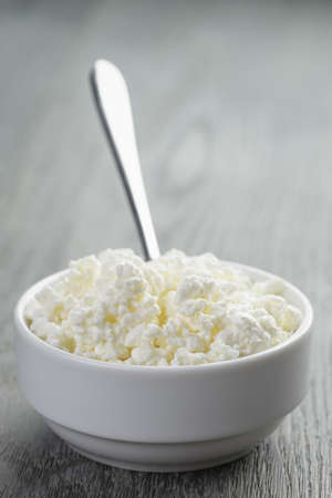 cottage cheese in white bowl on old tableの写真素材