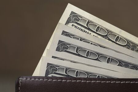 leather wallet on wood table with dollar billsの写真素材