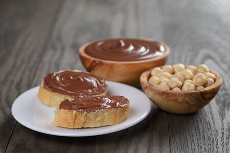 baguette with chocolate spread with nuts, on wooden tableの写真素材