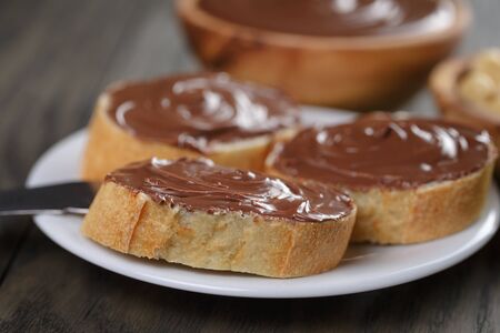 baguette with chocolate spread with nuts, on wooden tableの写真素材
