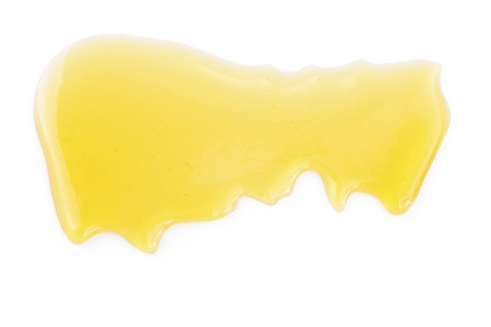fresh natural honey drop isolated on white backgroundの写真素材