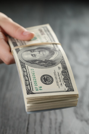 female hand hold bunch of dollars, closeupの写真素材