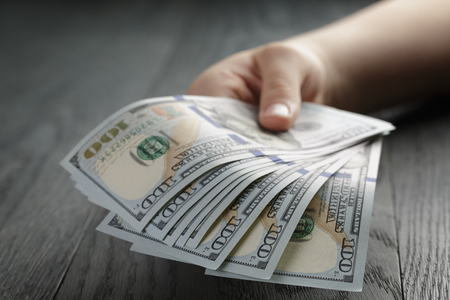 female hand hold bunch of dollars, closeupの写真素材