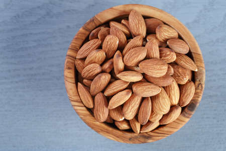 roasted almonds in bowl on blue wooden table