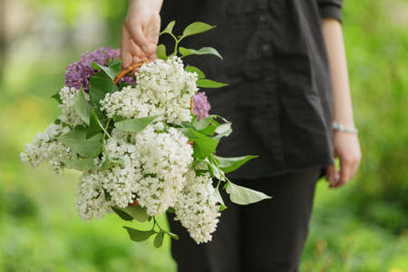 female teen girl hold basket full of lilac flowersの写真素材