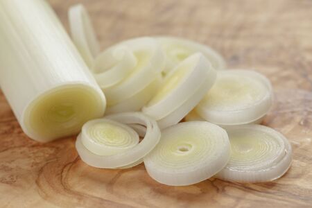 sliced fresh leek on olive boardの写真素材
