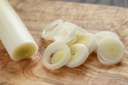 sliced fresh leek on olive boardの写真素材