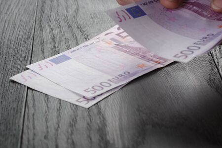 young female hands count euro bills on wood table, closeupの写真素材