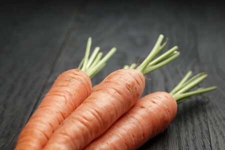 fresh organic carrots on wooden tableの写真素材