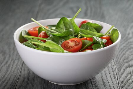 fresh summer organic salad with tomatoes cucumbers and spinachの写真素材