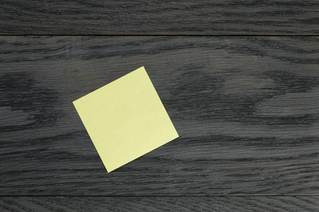 yellow sticky note on wooden table, template