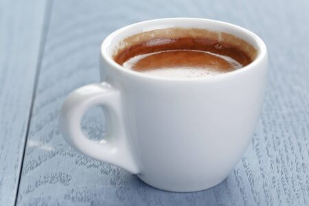 cup of fresh espresso on vintage blue table close upの写真素材