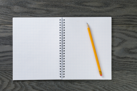 blank notepad with pencil on gray wood table, top viewの写真素材