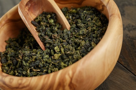oolong green tea in wood bowl, on oak tableの写真素材