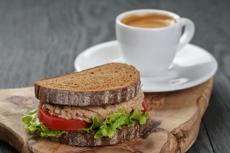 espresso and sandwich with tuna for breakfast or lunch on wood backgroundの写真素材