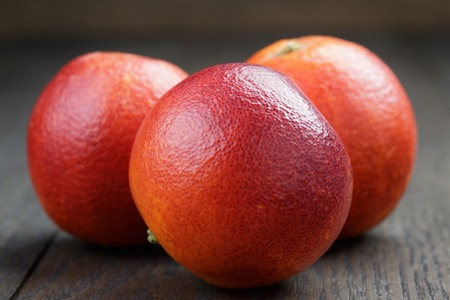 whole red sicilian oranges on wooden tableの写真素材